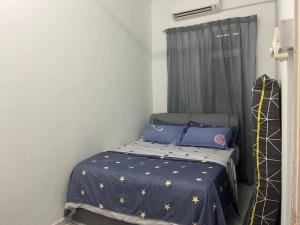 汝来Nilai Bronizam Homestay的一间小卧室,配有一张带蓝色棉被的床