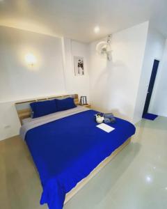 奈扬海滩Sun & Sea Nai Yang Phuket的一间白色客房内的蓝色床卧室