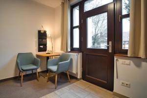 新格洛布索Luisenhof的一间设有两把椅子、一张桌子和一扇门的房间