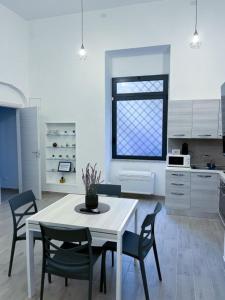 罗马DOMVS Ginori Testaccio的白色的厨房配有白色的桌子和椅子