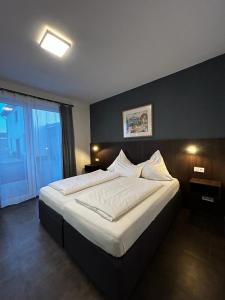 布格多夫Hotel Restaurant Ayhan的一间卧室配有一张带白色床单的大床