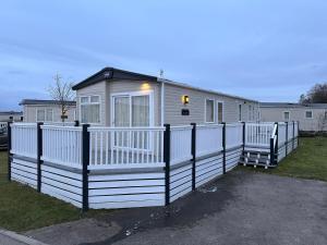 塔特舍尔Tattershall Lakes 6 berth with bath的前面有白色围栏的房子