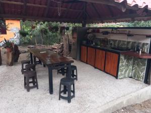 塔马林多Aura Bungalow的一张木桌和一些椅子以及一间厨房