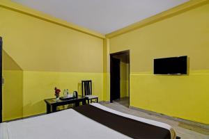 KhandagiriOYO Home Spacious Stay的一间卧室配有一张床和一台平面电视