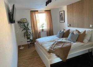 ArnoldshammerMorgensonne的卧室配有带枕头的白色床和窗户。