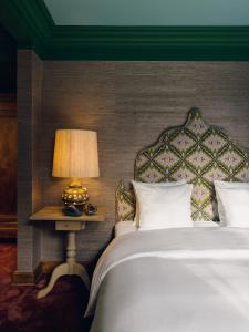 拉纳肯La Butte aux Bois的一间卧室配有一张床和一张桌子上的台灯