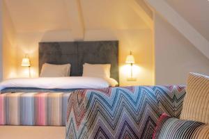 拉纳肯La Butte aux Bois的酒店客房,设有两张床和一张沙发