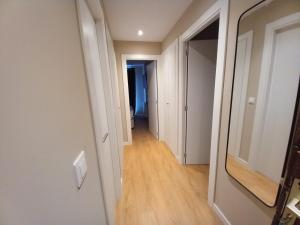 帕斯底拉卡萨艾迪信公寓的一间公寓的走廊,拥有白色的墙壁和木地板