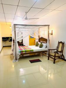 阿杭格默Riparian Ahangama的一间卧室配有一张带天蓬的床和两把椅子