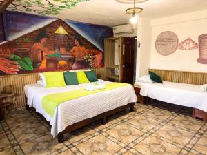 莱蒂西亚Eco Hotel El Refugio de La Floresta的一间设有两张床的客房,墙上挂着一幅画