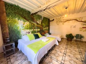莱蒂西亚Eco Hotel El Refugio de La Floresta的墙上画画的房间里设有两张床