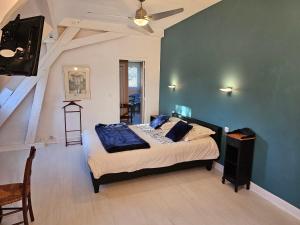 卢尔德La demeure aux Pins的一间卧室配有一张蓝色墙壁的床