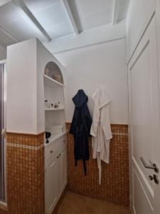 博格图Private villa relax 2 &spa的厨房配有白色橱柜和黑色衣服挂件