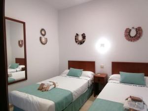 EsteponaCN-340 Suites的一间卧室配有两张床和镜子