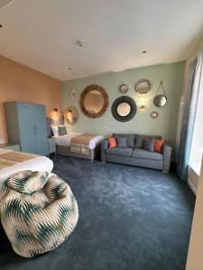 布莱克浦巴尔摩拉尔酒店的一间卧室配有一张床、一张沙发和镜子