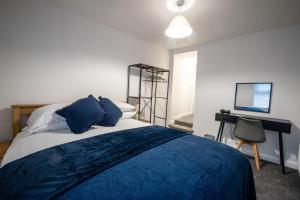莫克姆Seaside Apartments in the Centre of Morecambe的一间卧室配有一张床、一张书桌和一台电视