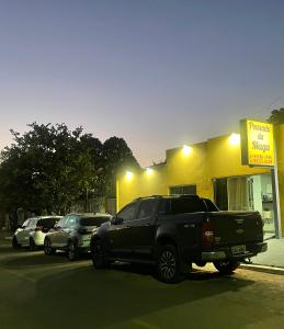 沙帕达-杜斯吉马朗伊斯POUSADA DA MAGA的停在商店前的一辆黑色卡车