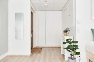 坦佩雷Beautiful apartment in the center of Tampere的一间拥有白色墙壁和植物的卧室