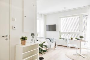 坦佩雷Beautiful apartment in the center of Tampere的白色卧室配有床和桌子