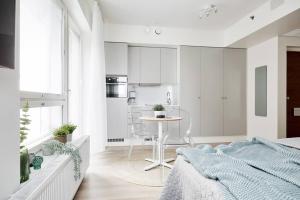 坦佩雷Beautiful apartment in the center of Tampere的一间卧室配有一张床铺和一张桌子,还设有一间厨房