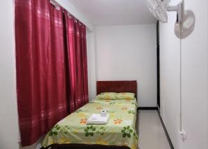 廷戈玛丽亚Hospedaje Vista Paraíso的一张小床,位于一个红色窗帘的房间