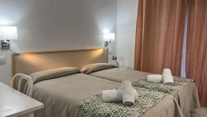塔拉戈纳塔拉戈纳阿罕布拉旅馆的两张位于酒店客房的床,配有毛巾