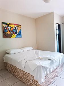 巴雷里尼亚斯Hotel Beira Rio Preguiças的墙上画的一张床上