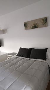 米哈斯Sun Love calypso的卧室配有一张带黑色枕头的白色床