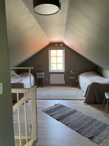 SliteVilla VitvikenA in Gotland Pool的阁楼卧室设有两张床和窗户。