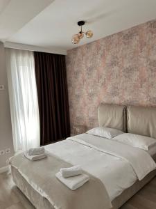 布加勒斯特Elegance的一间卧室配有一张大床和两条毛巾