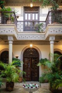 马拉喀什橘园别墅 - 罗莱夏朵酒店的庭院中植物阳台的建筑