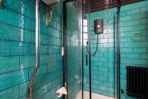 哈特尔普尔Dickens' Nook的带淋浴的浴室和蓝色瓷砖墙