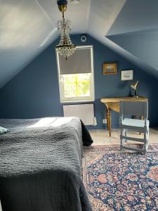 SliteVilla VitvikenB i Gotland Pool的一间卧室配有一张床、一张桌子和一个窗户。