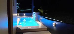 大雅台Staycation @ Sandari Batulao的夜间阳台上的游泳池