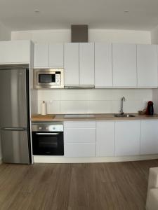 蒙托罗Casa Alma的厨房配有白色橱柜和不锈钢冰箱