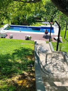 萨尔塔Casa Quincho ROMA的院子里的游泳池,有人坐在椅子上