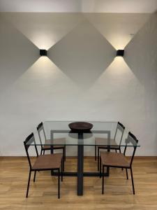 格拉纳达SlabonHome Serrallo的一张玻璃桌,配有两把椅子和两盏灯