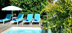 卡西奥皮The Central Villa - Kassiopi Corfu Villas的一组椅子和一把遮阳伞,位于游泳池旁