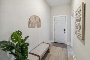 萨凡纳5 Min Drive to Downtown! Modern 3BR in Savannah!的白色走廊,带长凳和植物