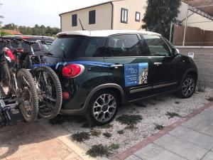 阿祖罗港Il PolpoLeo in Porto Azzurro Isola d'Elba的一辆小型汽车,旁边停放着自行车