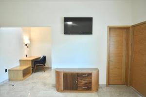 里奥韦尔德Hotel Plaza Rioverde的一间房间,配有一张桌子和一台墙上的电视