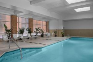 卡梅尔印第安纳波利斯北部万丽酒店 的游泳池位于带椅子和桌子的房间