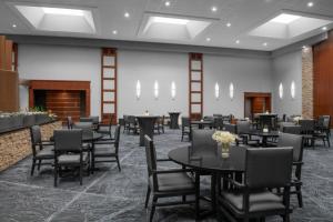 卡梅尔印第安纳波利斯北部万丽酒店 的一间带桌椅和壁炉的用餐室