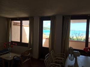 马里内拉Centro Servizi Marinella的客房设有3扇窗户和桌椅。