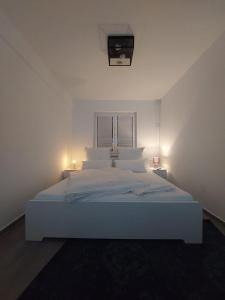 科隆Modern apartment cologne的白色的客房内的一张白色的床,配有两盏灯