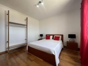 蓬塔德尔加达Villarelva的一间卧室配有一张带红色枕头的大床
