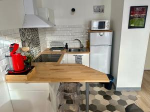 梅斯LeCathedrale : F2 au cœur de Metz !的厨房配有木桌和白色冰箱。