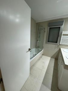 马德里Hotelly Recuero的带淋浴和盥洗盆的白色浴室