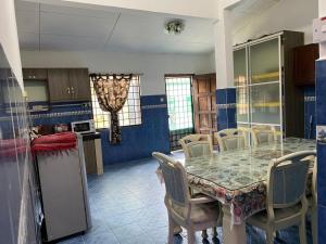 汝来Nilai Bronizam Homestay的厨房以及带桌椅的用餐室。