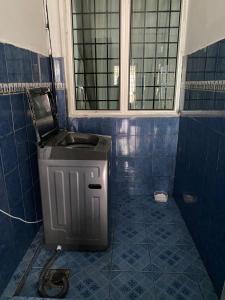 汝来Nilai Bronizam Homestay的一间带水槽的浴室和蓝色瓷砖地板。